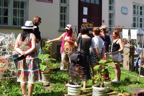 Uczestnicy i organizatorzy podczas pikniku przed budynkiem biblioteki.